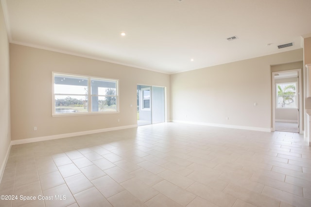 unfurnished room with crown molding and light tile patterned floors