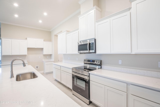 kitchen with stainless steel appliances, white cabinetry, sink, and ornamental molding