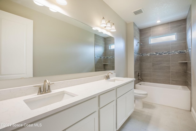 full bathroom with tile patterned flooring, toilet, vanity, and tiled shower / bath