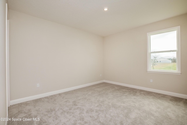 unfurnished room featuring light carpet