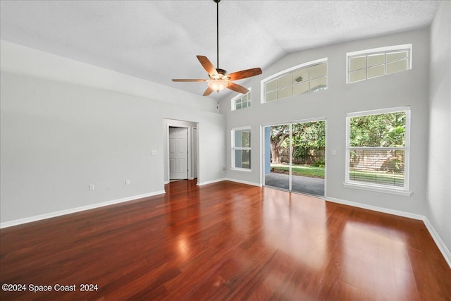 spare room with a textured ceiling, dark hardwood / wood-style floors, and a healthy amount of sunlight