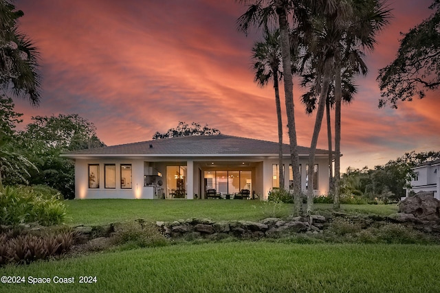 back house at dusk with a yard