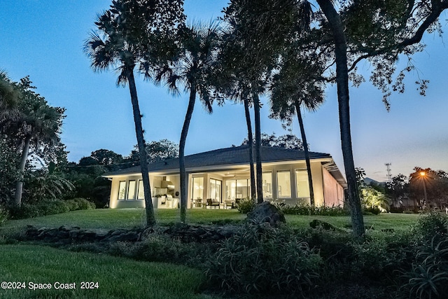 property exterior at dusk with a lawn