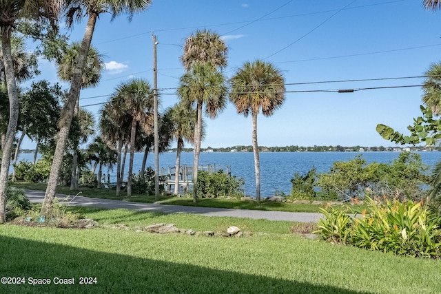 surrounding community with a yard and a water view