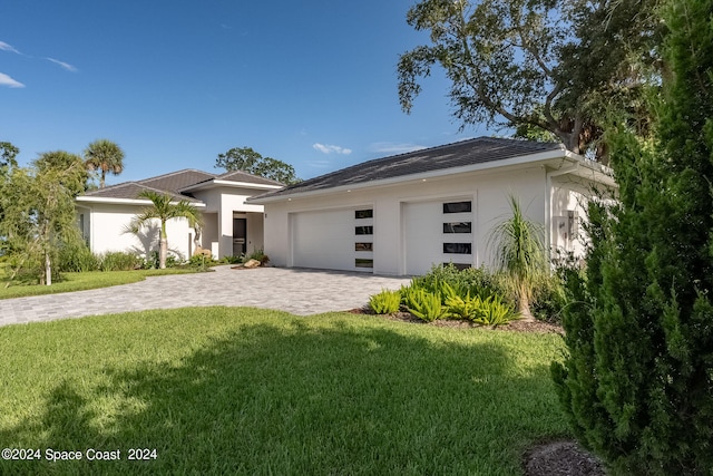 view of front of home with a front lawn and a garage