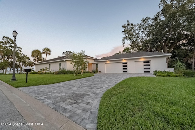 view of front of house with a yard and a garage