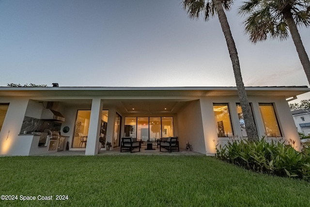 rear view of house with a patio and a yard