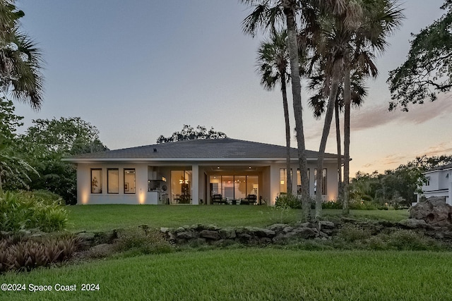 back house at dusk with a yard