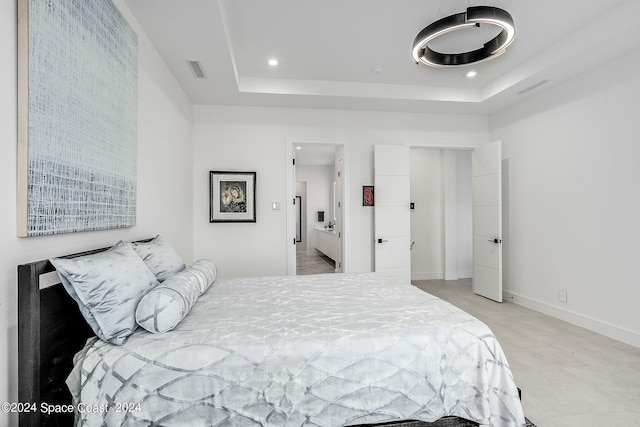 bedroom with a tray ceiling and light tile patterned floors