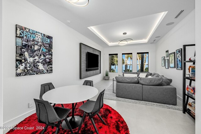 tiled dining space featuring a raised ceiling