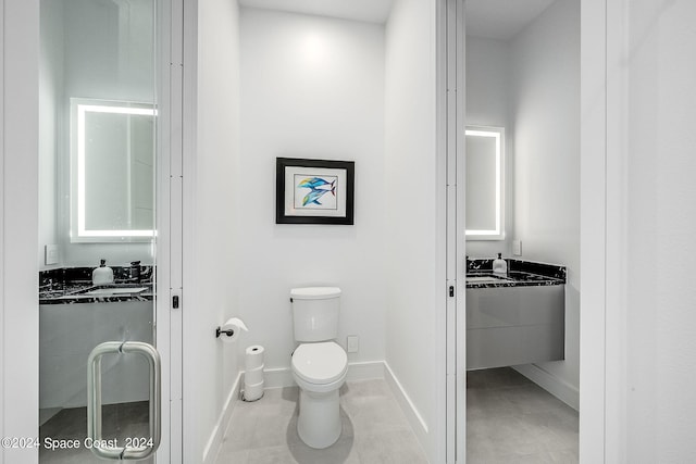 bathroom with toilet and tile patterned flooring