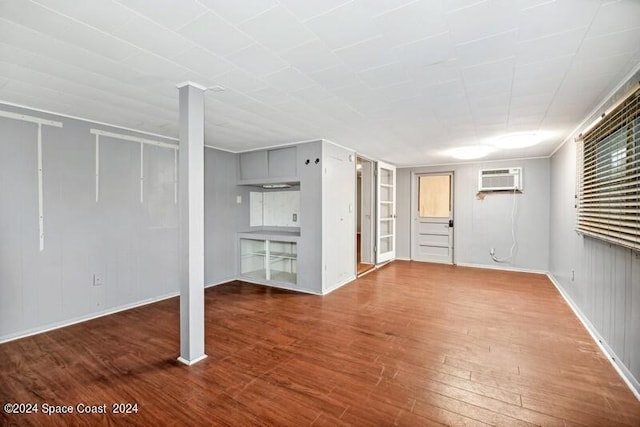 unfurnished living room featuring hardwood / wood-style flooring and a wall mounted air conditioner