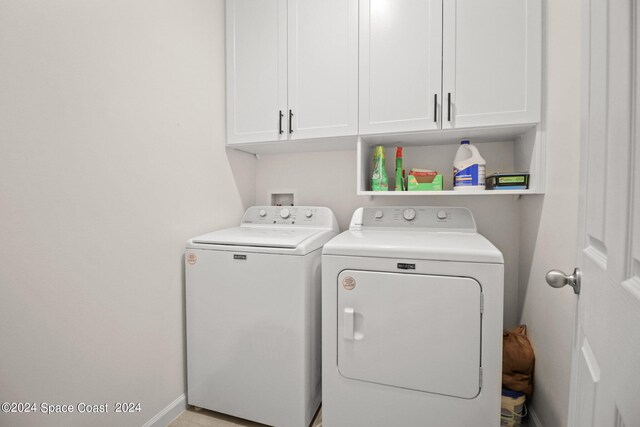 washroom featuring cabinets and independent washer and dryer