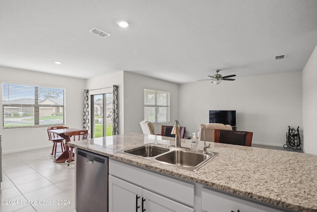 kitchen featuring dishwasher, sink, ceiling fan, white cabinets, and light tile patterned flooring