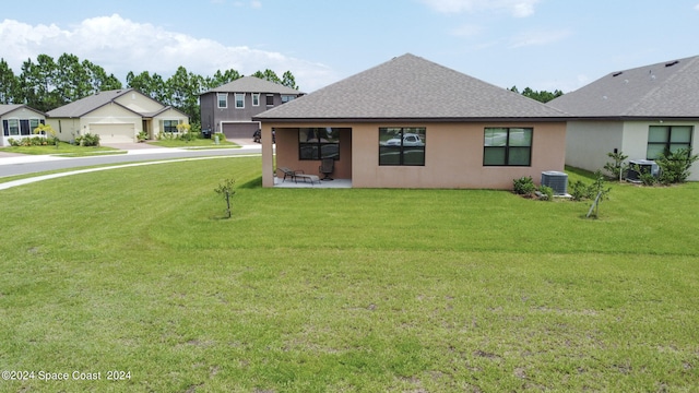 exterior space with a lawn, a garage, and central AC unit