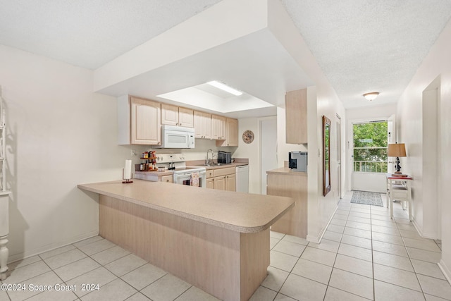 kitchen featuring light tile patterned floors, light brown cabinets, kitchen peninsula, and white appliances