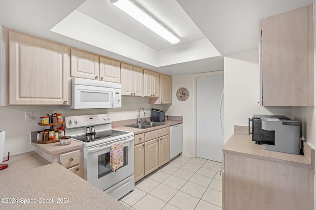 kitchen with sink, white appliances, light tile patterned floors, and light brown cabinets