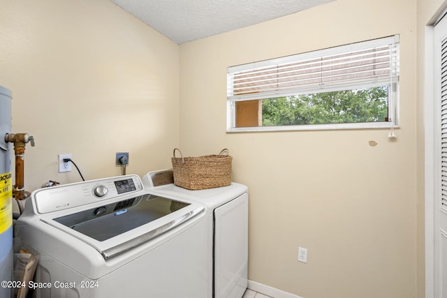 laundry room with a textured ceiling and separate washer and dryer