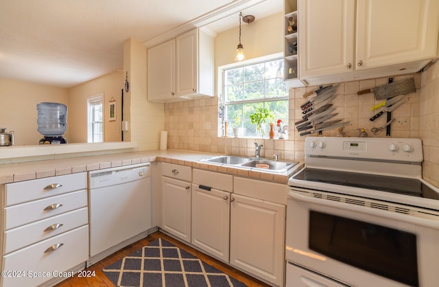 kitchen with sink, tasteful backsplash, white appliances, and a healthy amount of sunlight