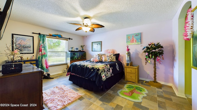 bedroom with a textured ceiling and ceiling fan