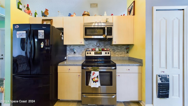 kitchen featuring stainless steel appliances, backsplash, and light wood-type flooring