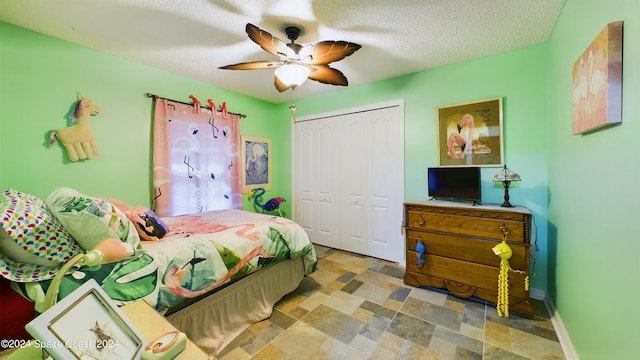 bedroom with a textured ceiling, ceiling fan, and a closet