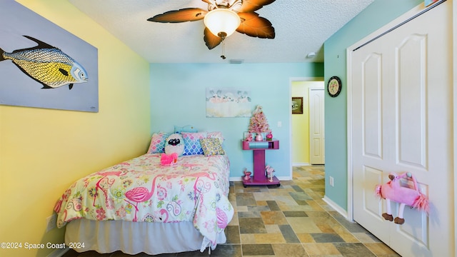 bedroom featuring ceiling fan and a textured ceiling