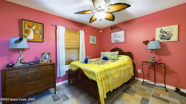 bedroom with ceiling fan and a textured ceiling