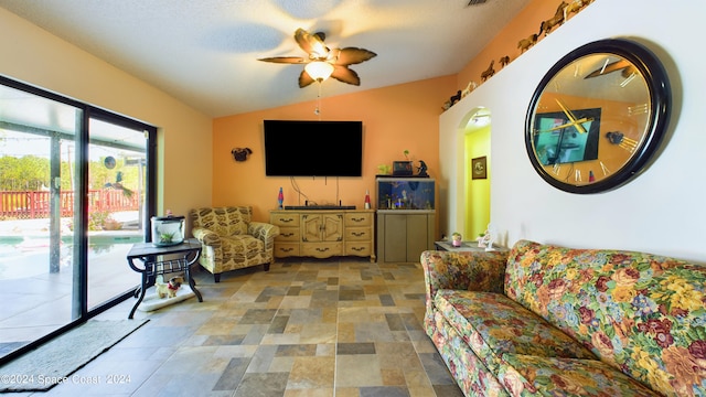 living room with ceiling fan, a textured ceiling, and lofted ceiling