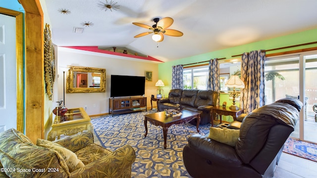 living room with ceiling fan, light tile patterned floors, and vaulted ceiling