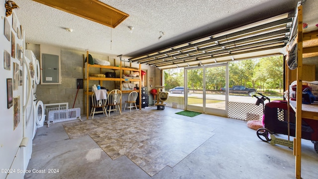 garage with electric panel and separate washer and dryer