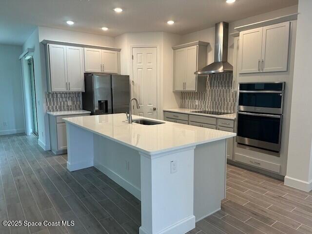3742 Ornis Ct, Grant-Valkaria, FL 32950 - kitchen featuring wall chimney exhaust hood, black appliances, a sink, dark wood-style floors, and baseboards