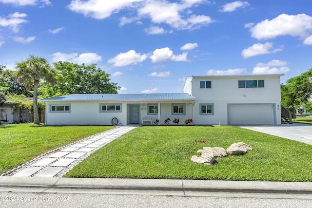 view of front of house with stucco siding, driveway, a front lawn, and a garage