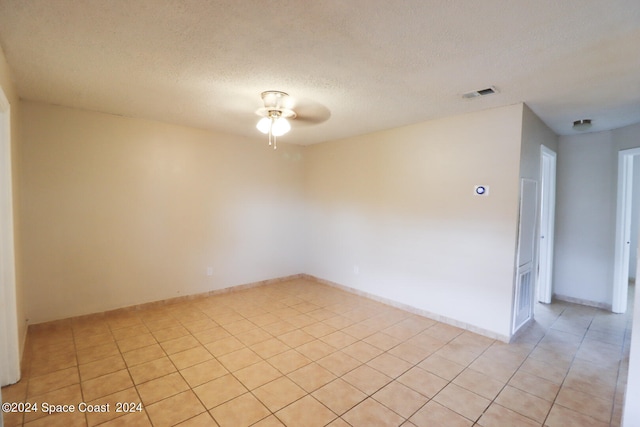 tiled empty room with a textured ceiling and ceiling fan