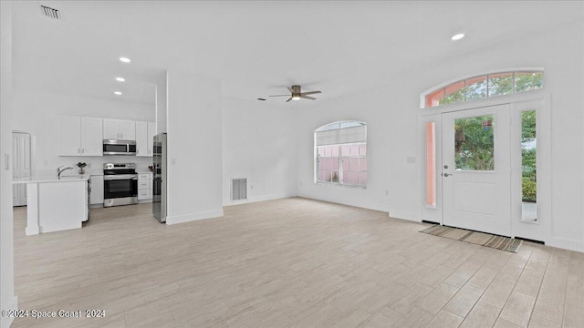 foyer entrance featuring ceiling fan, sink, and light hardwood / wood-style floors