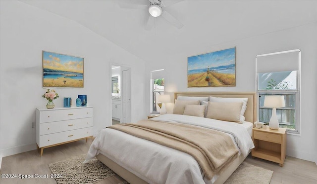 bedroom with ensuite bath, vaulted ceiling, light hardwood / wood-style flooring, and ceiling fan