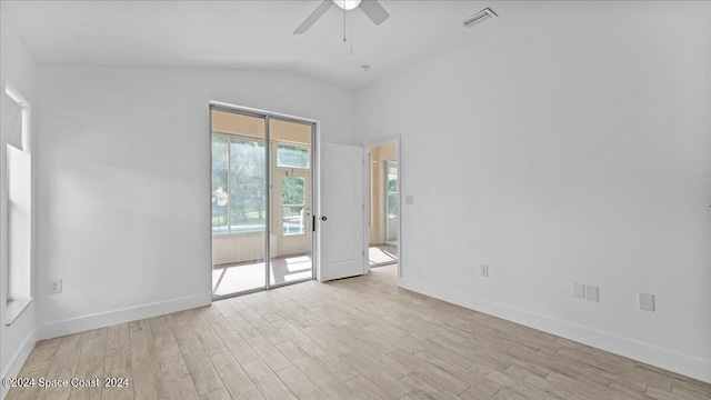 spare room with ceiling fan, light wood-type flooring, and vaulted ceiling