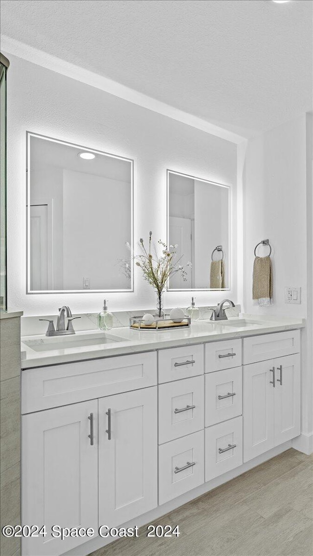 bathroom featuring a textured ceiling, vanity, and wood-type flooring