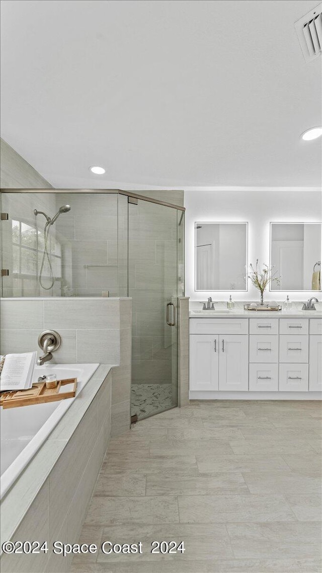 bathroom featuring vanity and independent shower and bath