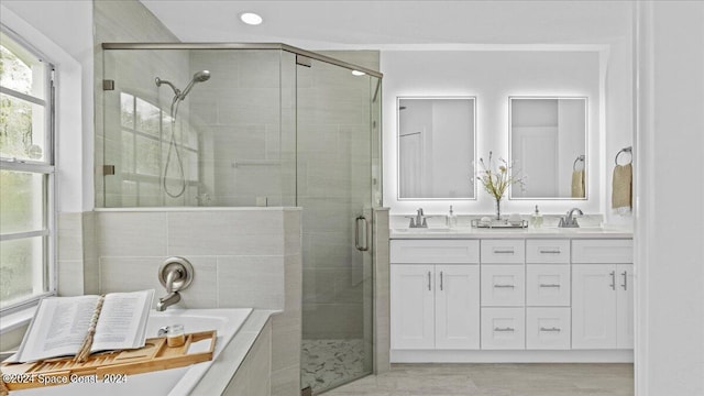 bathroom featuring vanity and independent shower and bath