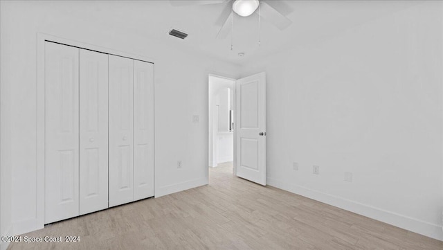 unfurnished bedroom with light hardwood / wood-style flooring, ceiling fan, and a closet