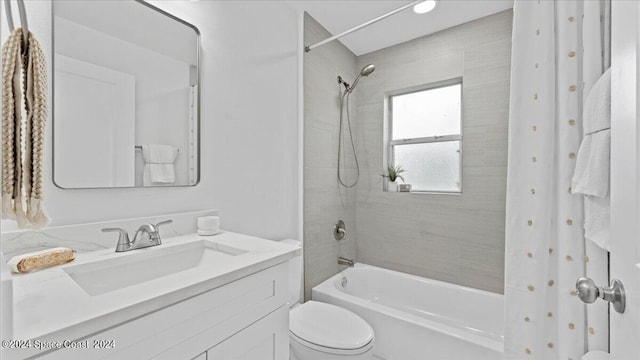 full bathroom featuring tiled shower / bath, vanity, and toilet