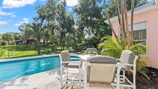 view of pool with a lawn and a patio area