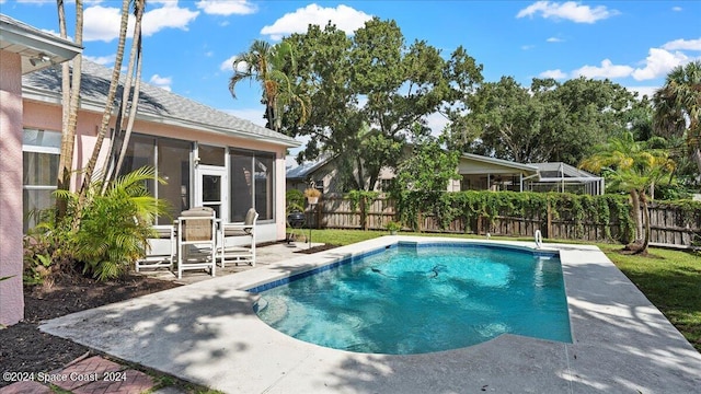 view of swimming pool featuring a patio and a sunroom