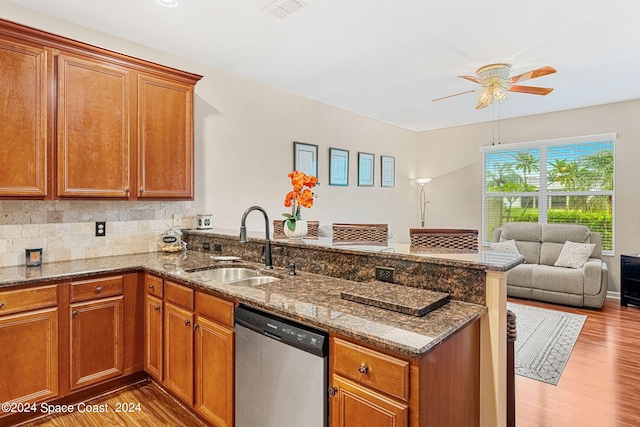 kitchen featuring dark stone countertops, kitchen peninsula, sink, ceiling fan, and stainless steel dishwasher