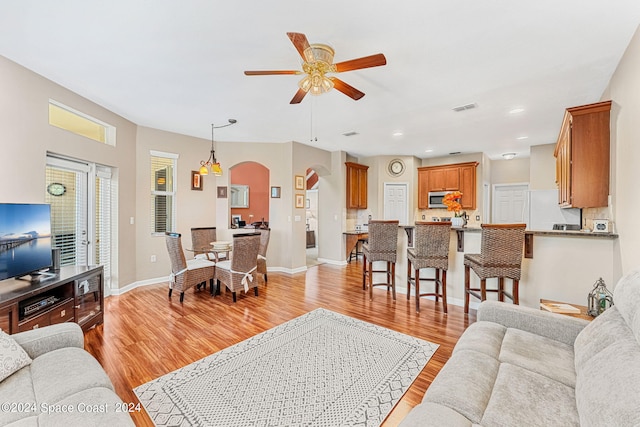 living room featuring light wood-type flooring and ceiling fan