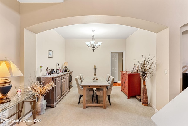 dining area featuring light colored carpet and a chandelier