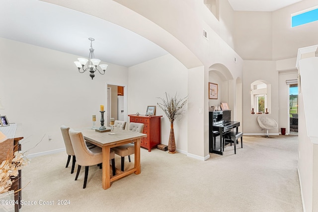 carpeted dining space with a high ceiling and an inviting chandelier