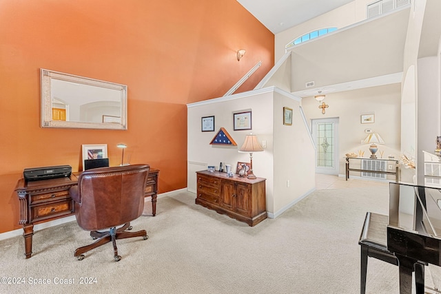 office space with high vaulted ceiling and light carpet