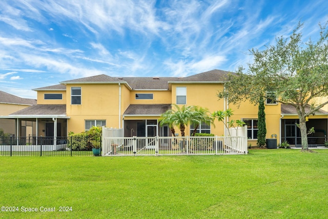 rear view of property with a yard, cooling unit, and a sunroom